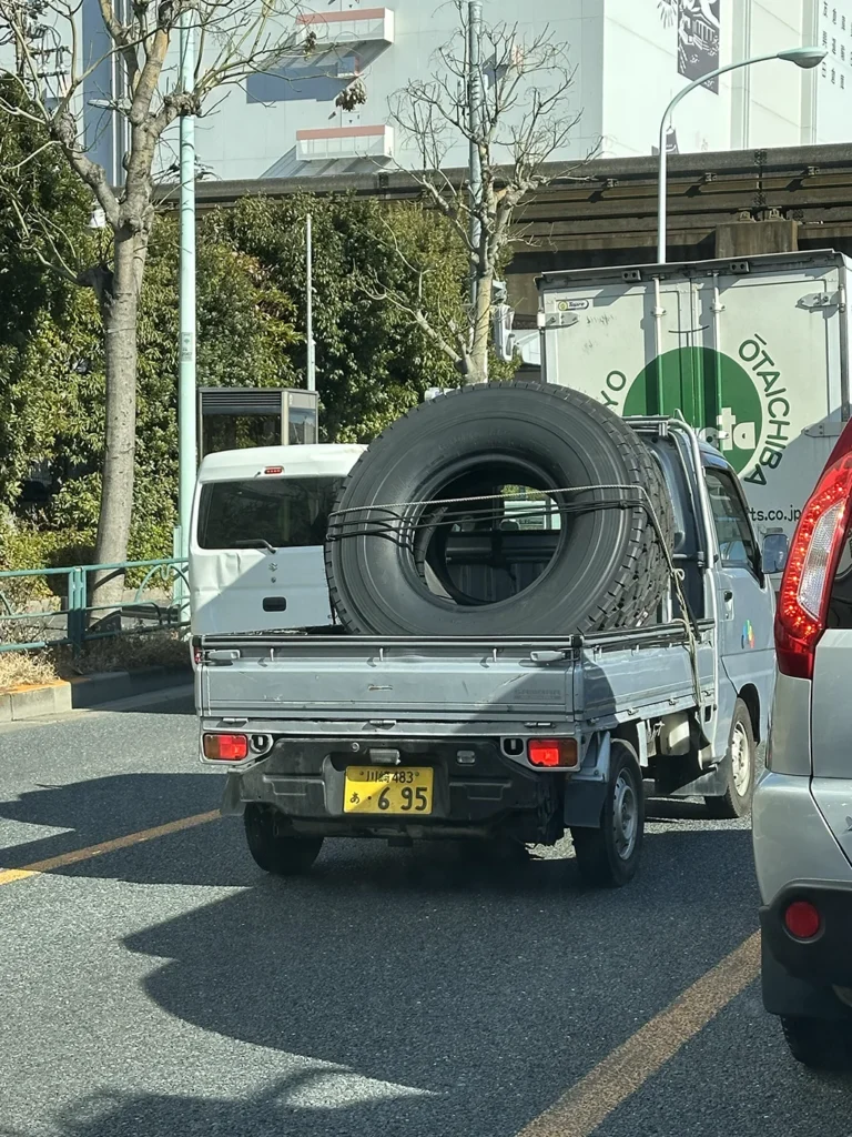 大きなタイヤ1つを軽トラで運ぶ。軽トラが履いているタイヤの大きさと比較すると。。小人さんが頑張ってる。