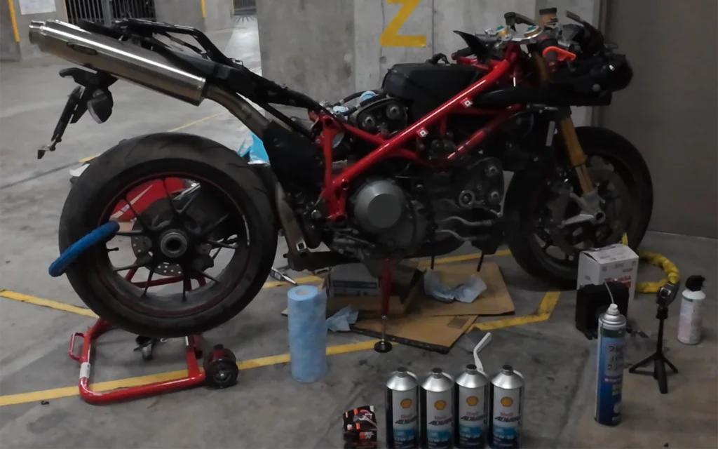 地下駐車場で組み上げ前の状態　エンジンオイルやその他雑然と置かれてます。